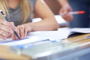 Student drawing line in exercise book