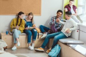 Multicultural group of high school teenage students reading books during school break