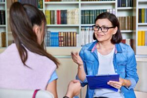 Woman school psychologist, teacher, social worker, mentor working with teenage girl