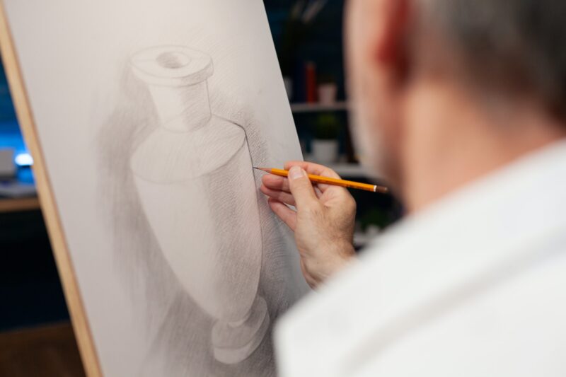 Closeup of original pencil drawing of vase on paper canvas done freehand by elderly man