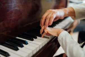 hand of an experienced pianist helping young students