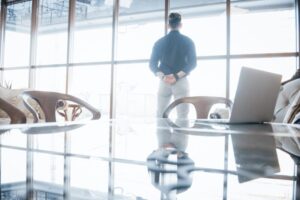 Young business executive and leader standing confidently in the the top floor office