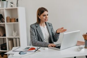 Young business woman with little indignation communicates in Skype with partners while sitting in h