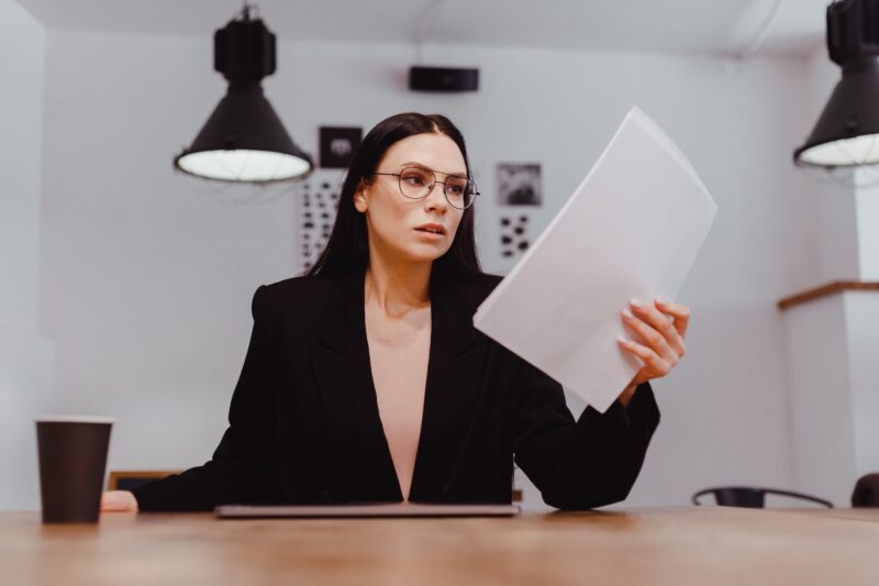 Serious businesswoman boss holding document indignantly