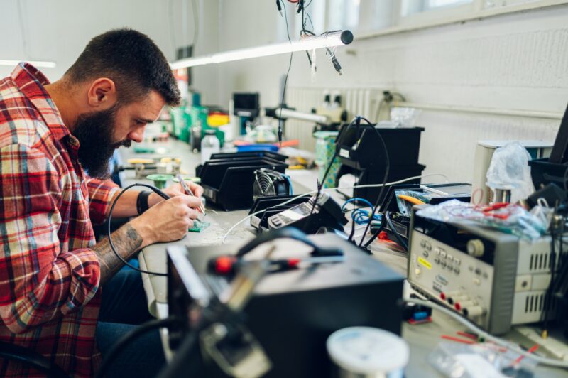 Electronics engineer working in a workshop with tin soldering parts