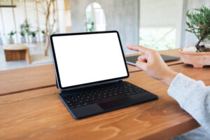 a woman using and pointing finger at tablet pc with blank desktop white screen as a computer pc