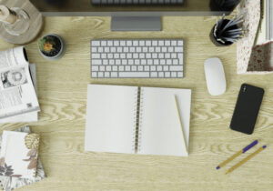 Workrooms with PCs, books, pens and smartphones on the table.