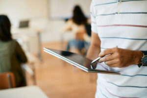 Close-up of professor using touchpad in the classroom.