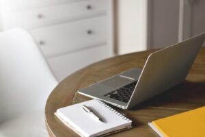 Desk with laptop, notebook and yellow binder