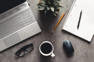 laptop and book, coffee on gray background, Top view of office desk on textured