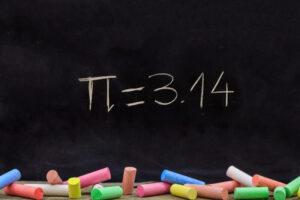 Pi number, mathematical constant chalk drawing on a school black board