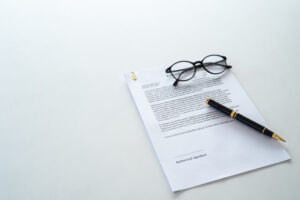 White table with paper contract detail and empty space to sign authorized signature.