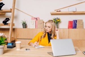 clothing store manager writing notes at workplace