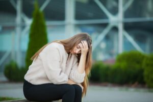 Upset woman with problems sitting on a bench.