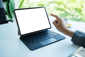 a woman using and pointing finger at tablet pc with blank desktop white screen as a computer pc
