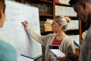College student solving math on whiteboard