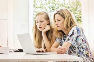 Mother and daughter using laptop