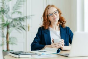 Pleased female teacher makes research work on laptop computer