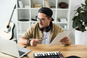 young musician working on new project at modern workplace