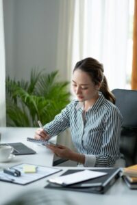 Business asian hand holding pencil and writing note on wood table,Checklist Notice Remember Planning
