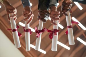 College graduates holding diplomas close up