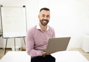 Glad confident attractive caucasian mature man in shirt use laptop in coworking office interior with