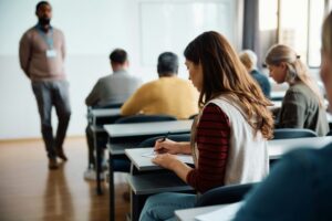 Rear view of woman writing an educational exam in the classroom.