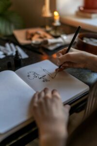Artist holding fountain pen drawing with ink, creating artwork