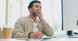 Asian man, face thinking and idea with computer, planning and brainstorming for success in programm