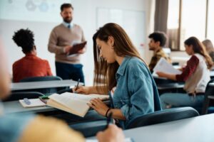 Female student taking notes during a class at the university.