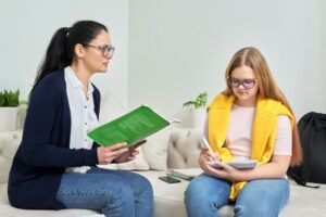 Female teacher studying individually with teenage girl