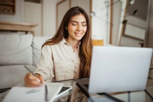 Glad millennial mixed race lady student typing on laptop, watch video lesson, has video call with