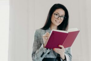 Beautiful business teacher plans her lessons, educates high school student