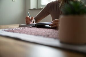 Woman, student, writing with pencil in notepad