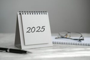 Desk calendar 2025, notebook, glasses and pen on the table