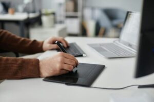 Man Using Pen Tablet Editing Photo or Video at Office Workplace