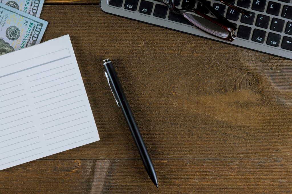 Keyboard of computer PC with dollar money as e-commerce with pen and glasses for vision