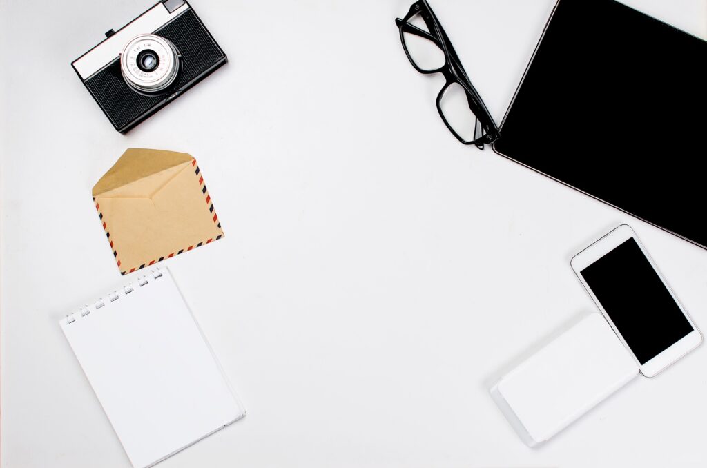 Workplace with tablet, smartphone, pen, notepad and glasses.