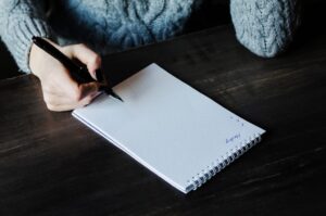 Girl holding pen. Notebook and pen. Business woman