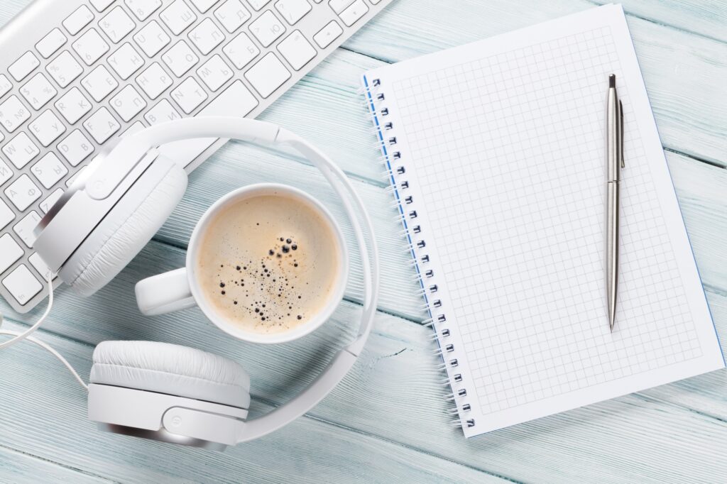 Headphones, coffee, notepad and pc