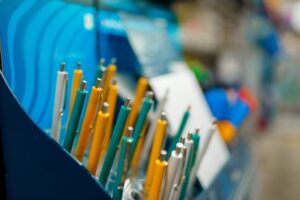 Shelf with pens in stationery store, nobody